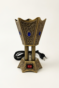 Antique-gold and blue electric bakhoor burner on a studio background